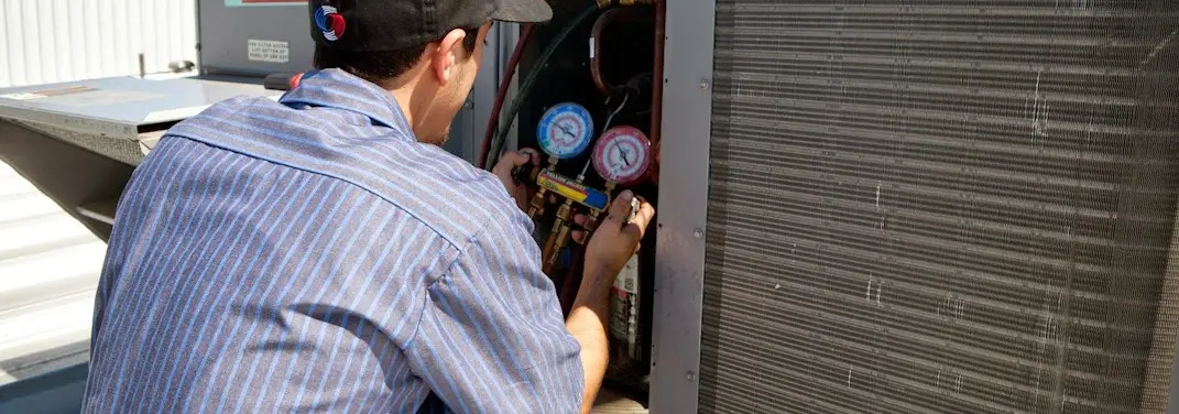 HVAC technician servicing a condenser unit in Bluffton