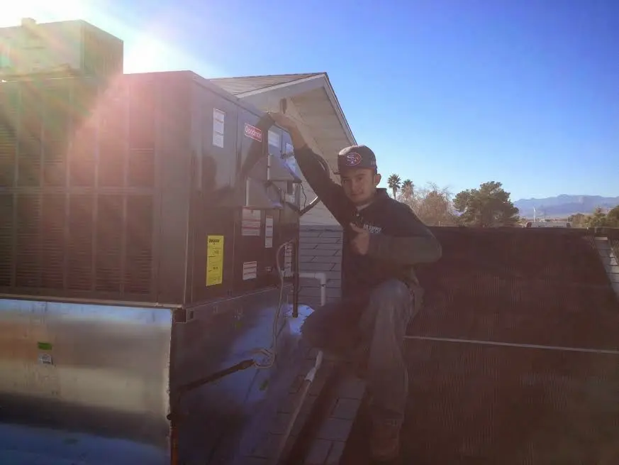HVAC technician performing AC Tune-Up on a rooftop unit in Bluffton